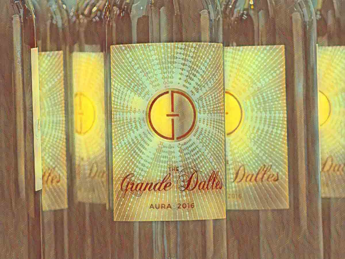 Bottles in a row showing the sunshine Aura Fund wine label.